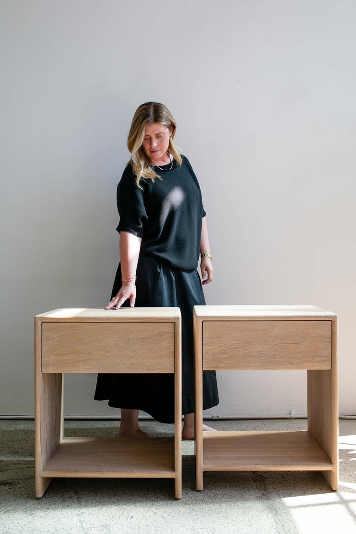 Esterina Gentilcore standing with a pair of handcrafted oak nightstands in her California studio.
