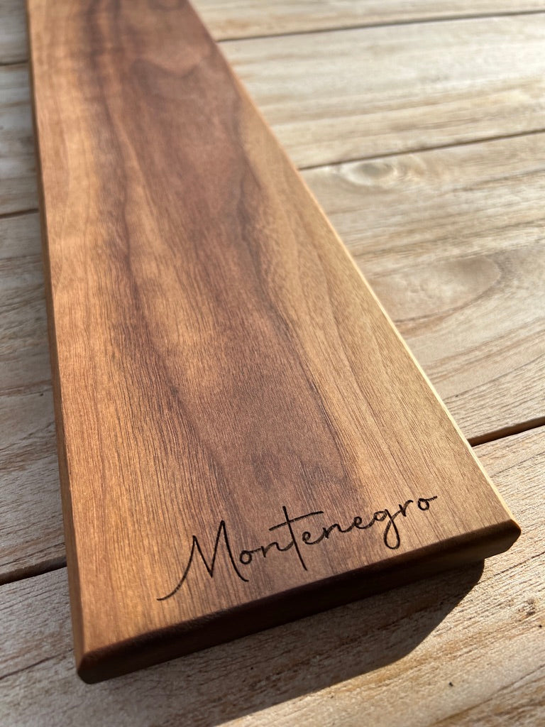 Walnut board with elegant engraved family name — example of what works well for custom engraving.